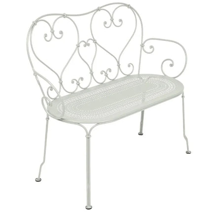 Colorful Fermob 1900 decorative bench with curved metal design and vibrant blue finish, ideal for stylish outdoor seating.