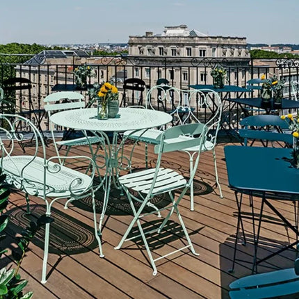 Green Fermob 1900 decorative metal bench with a simple, elegant design suitable for indoor or outdoor seating.