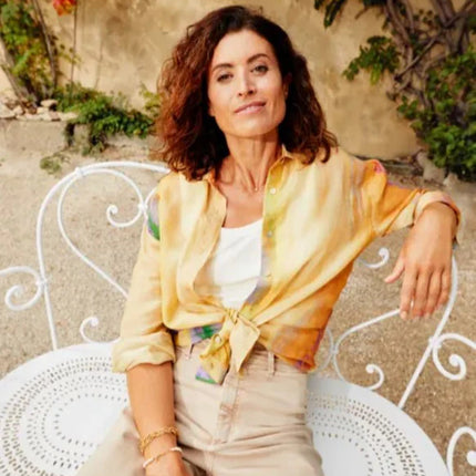 Decorative Fermob 1900 Bench with curved metal design, ideal for outdoor garden or patio seating.