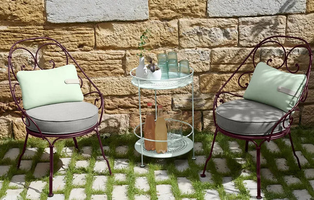 Fermob 1900 Cabriolet outdoor armchair with cushion, metal frame perfect for restaurant or cafe outdoor seating.