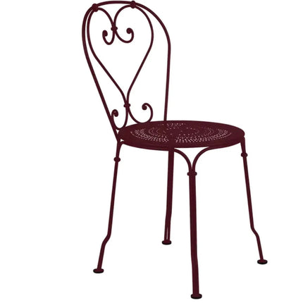 Fermob 1900 outdoor chair with curved metal frame and colorful woven seat, ideal for patio or garden seating.