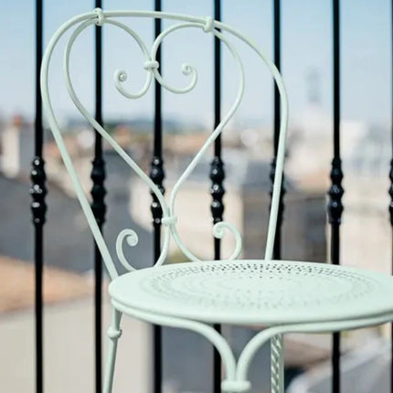 Fermob 1900 outdoor chair with colorful woven seat and curved metal frame, perfect for patio or garden seating.