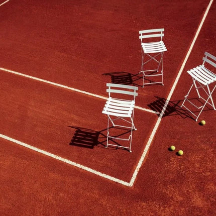 Fermob Bistro High Stool, foldable bar chair with metal frame and wooden seat, suitable for outdoor restaurant or hotel bar setting.