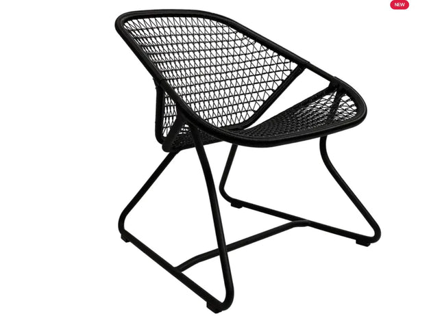 Fermob Sixties low armchair, woven lounge chair with a sleek, mid-century modern design, showcasing a comfortable seat and stylish frame.
