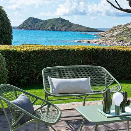 Fermob Sixties outdoor sofa with colorful cushions and sleek, modern design, perfect for patio or garden lounging.