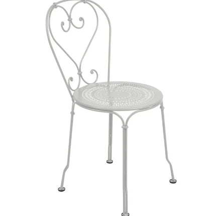 Fermob 1900 outdoor chair with painted metal frame and slatted seat, designed for outdoor hotel or cafe seating.